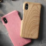 Two wooden iPhone XR cases resting on a bed of moss.